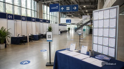 Pabellón de feria laboral con stands numerados, tótems QR, señalética de recorrido y un panel vertical de vacantes impresas.